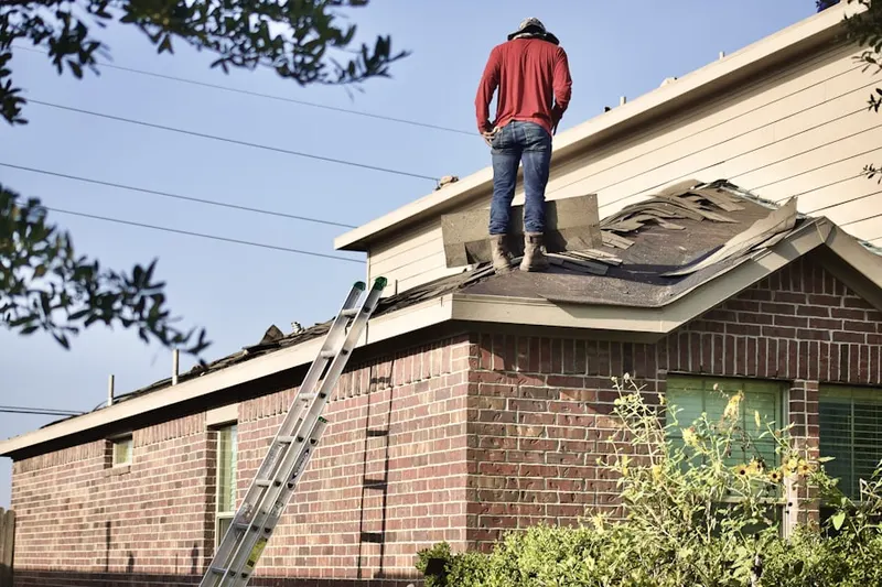 Professional roofer working on a residential roof in Broening